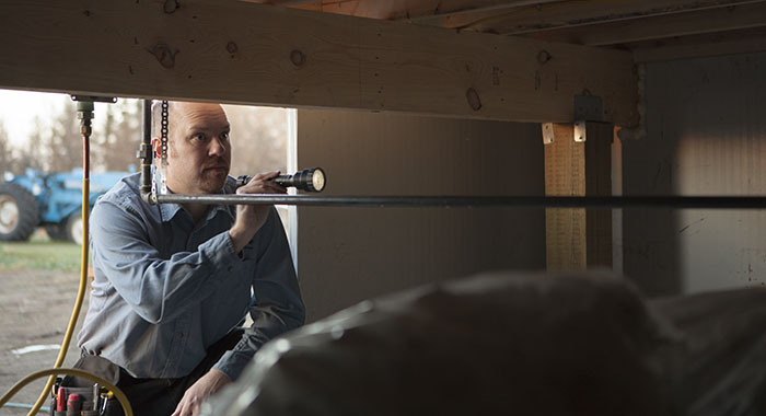 home inspector inspecting a crawl space in Camrose, AB