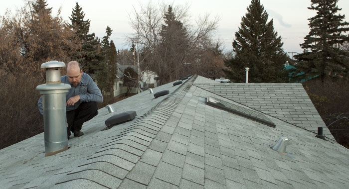 home inspector inspecting a roof in Camrose